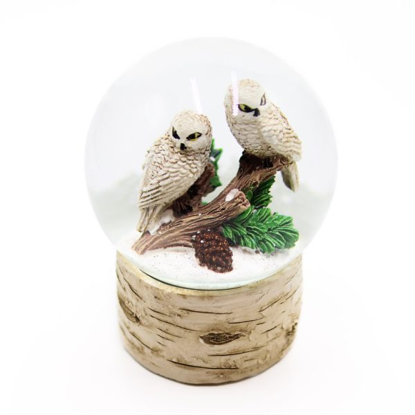 snowy owl pair sitting on a branch together in a birch based snow globe.