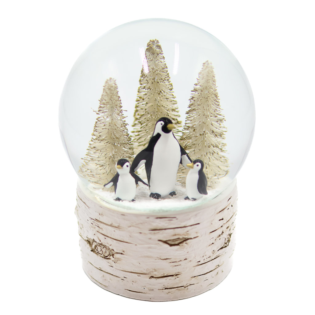 penguin trio snow globe abbott two baby penguins hold a the flipper of an adult penguin in front of three golden fir trees inside this snow globe.