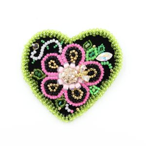 beaded heart brooch with lime green border and pink heart, it is a photo of the brooch for display purposes.