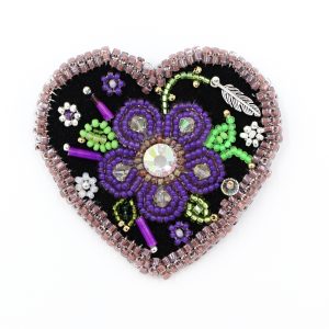 beaded heart brooch with purple border and flower, it is a photo of the brooch for display purposes.