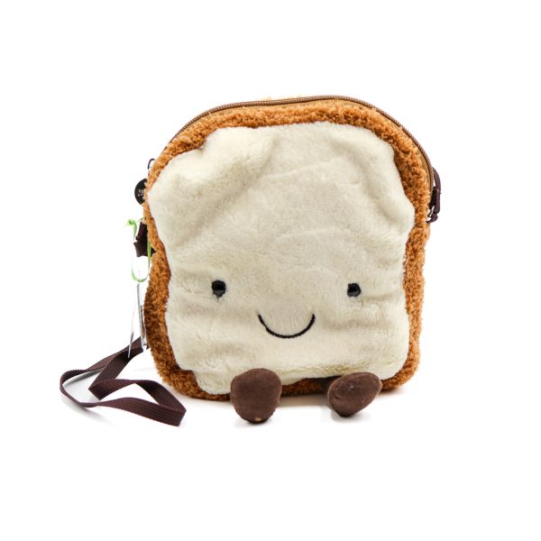 Photographed against a white background, this Jellycat plushie is in the shape of a piece of smiling toast. It is also a bag.