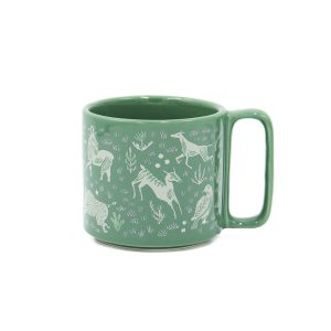 A green mug with the design of a rabbit riding a bicycle on e side and a tyrannosaurus riding a bicycle on the other.