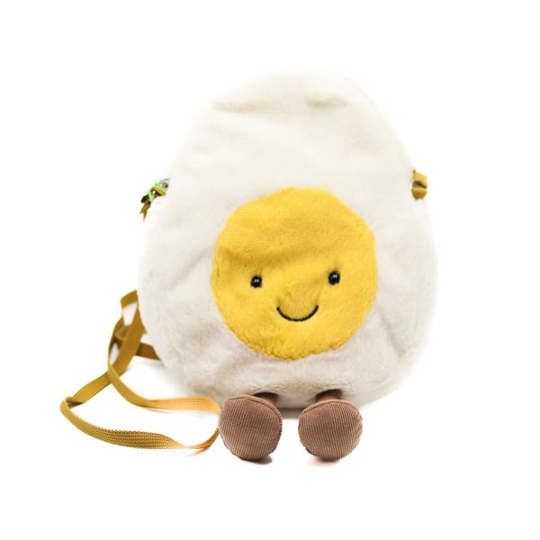 Photographed against a white background, this Jellycat plushie bag is in the shape of a hard boled egg cut in half, with a smiling yolk.