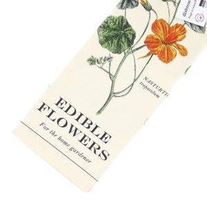 Image of a tea towel from above and mostly on the right hand side of the image square. It features different varieties of edible flowers.