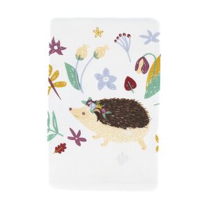 image of a tea towel from above and mostly on the right hand side of the image square. It features flowers and hedgehogs drawn all over it in a childish style.