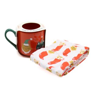 orange mug with christmas cats and a tea towel next to it