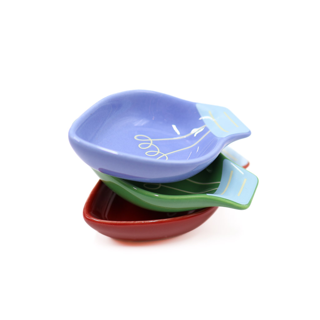 three of the dishes nested in a stack of red, green, and blue from bottom to top.
